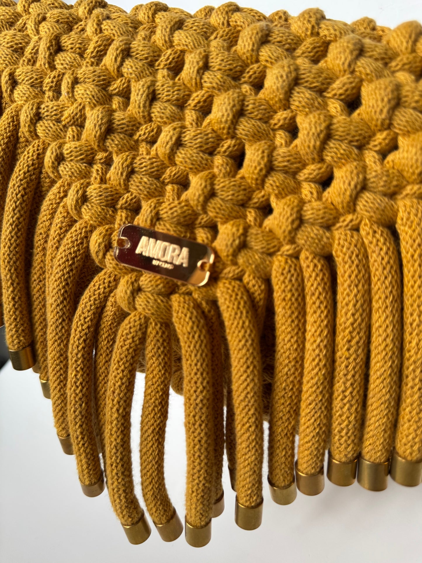 Gold braided cord with a brand tag on a white background